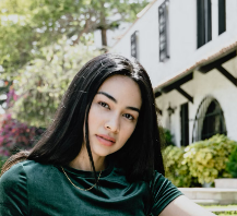 Woman with black hair sitting outside